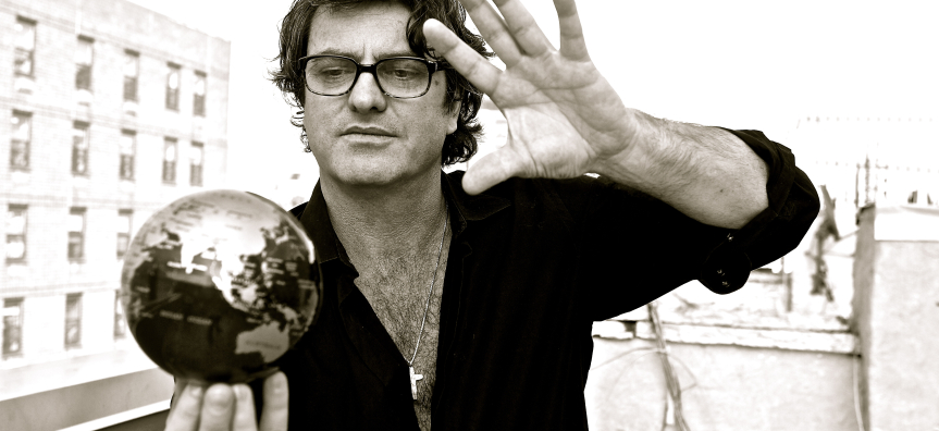 Founder of Manhattan Short, Nick Mason holds a small silver globe in his hands. The photo is in black and white